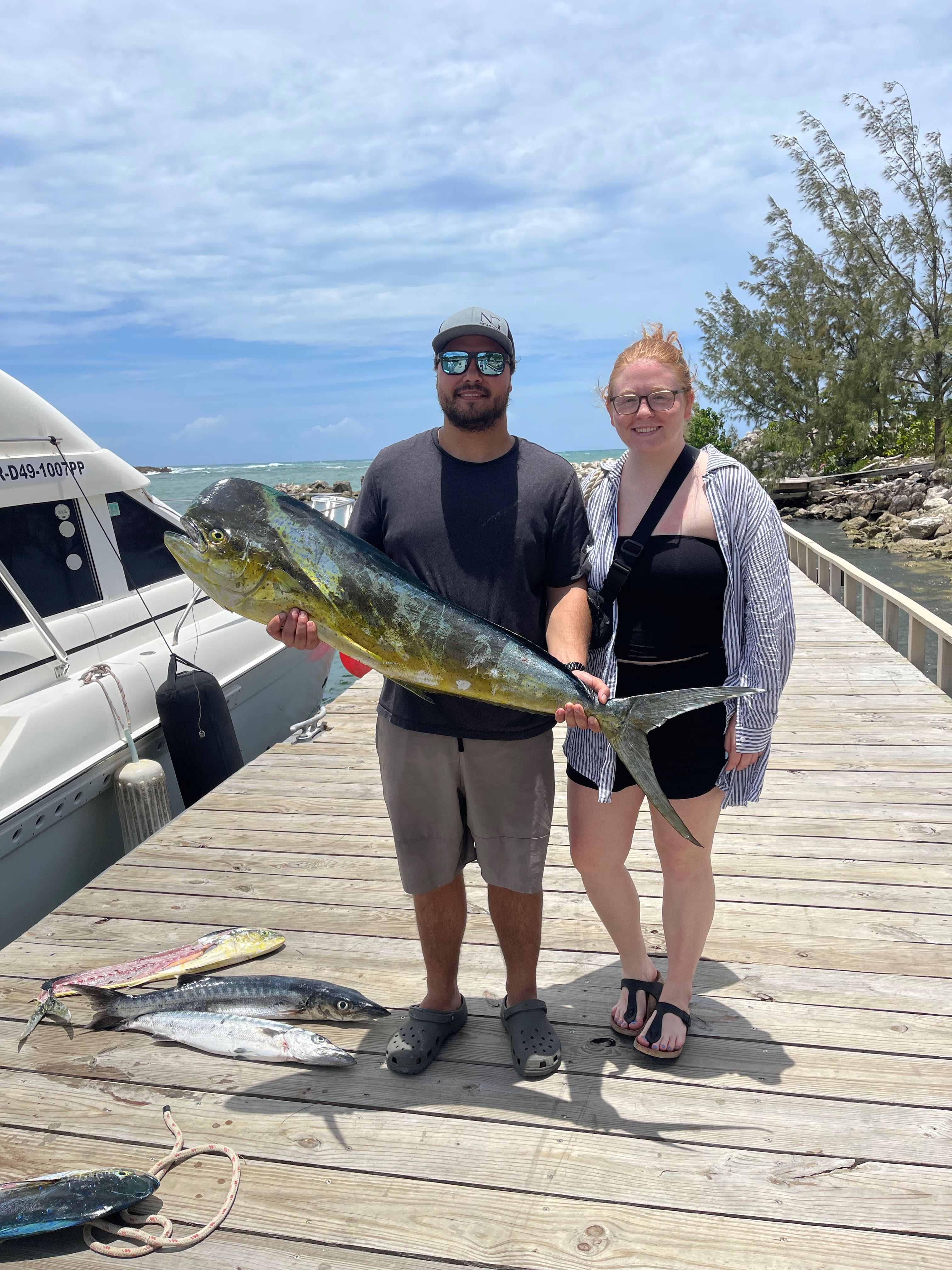 Fishing charter catch display with mahi mahi and great barracuda on dock in Puerto Plata