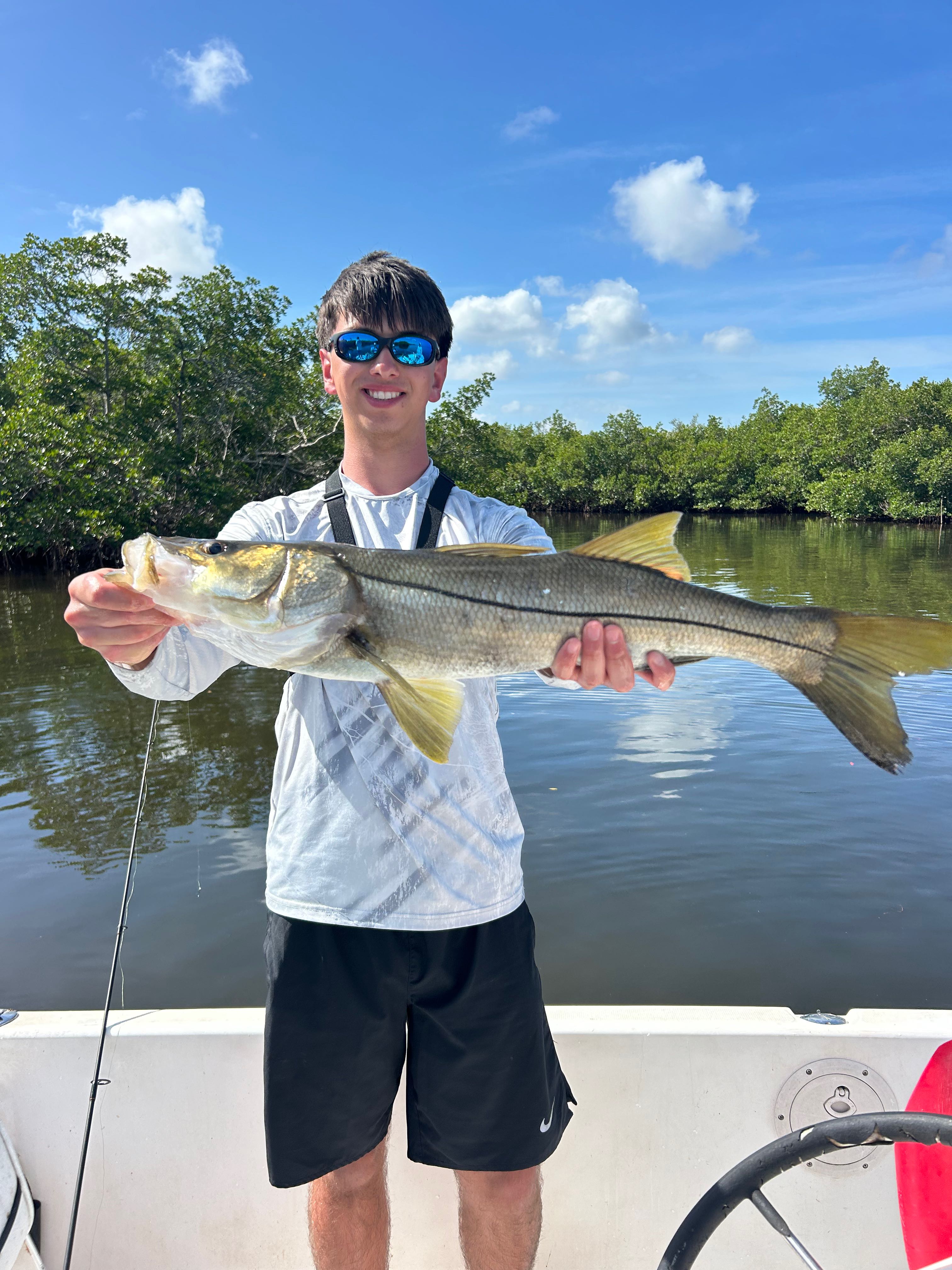 Snook catch displayed on fishing boat in Punta Gorda FL waters with mangroves in background