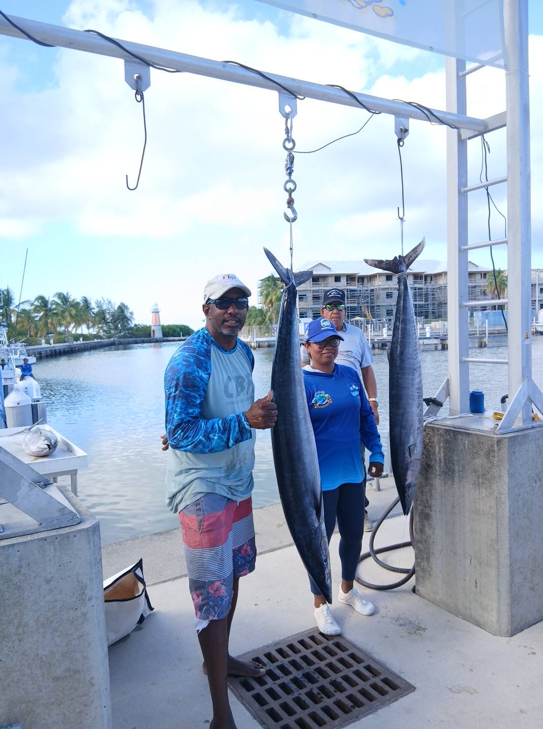 Two wahoo fish hanging from fishing boat scale in West Bay marina