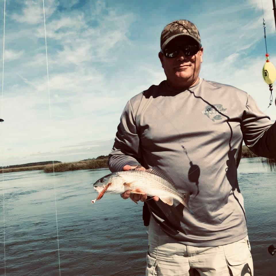 A fisherman holding their catch in SC