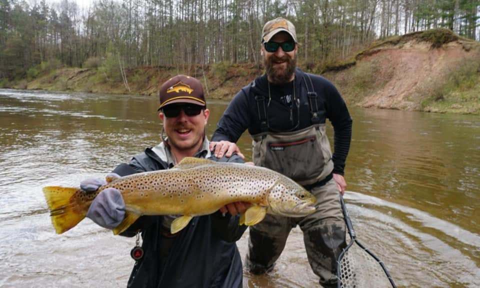Angler catching a rainbow trout in MI