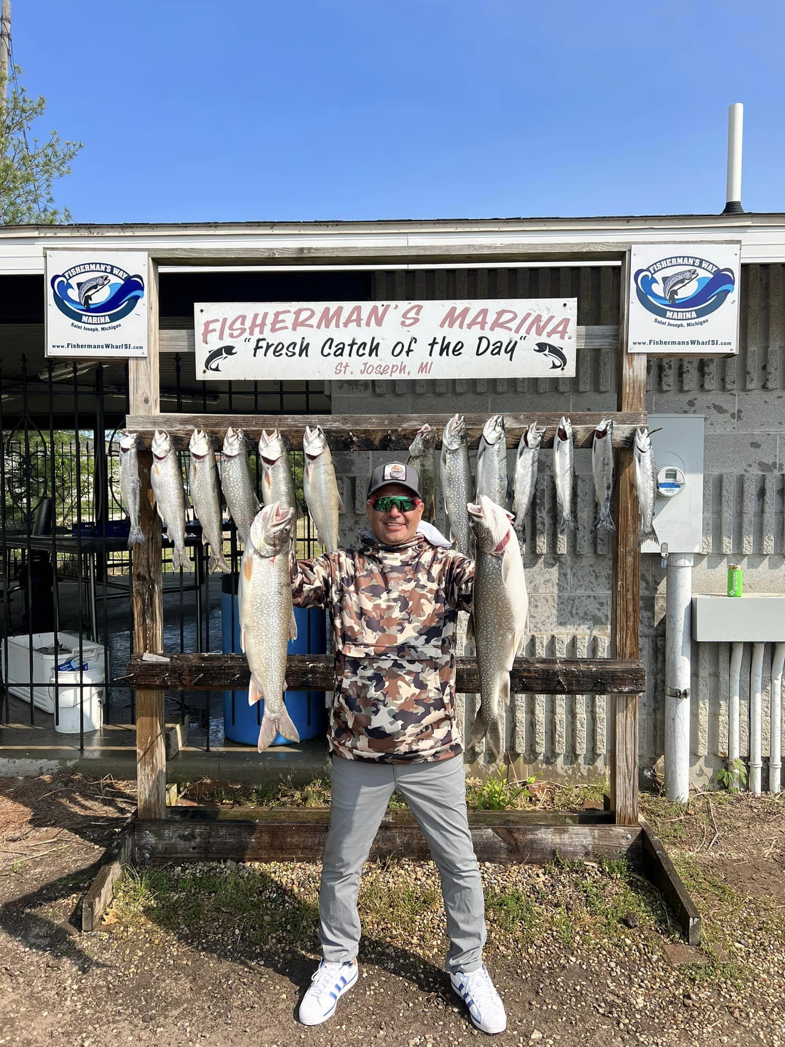 A person fishing for 3 lake trout and bluefish in St. Joseph