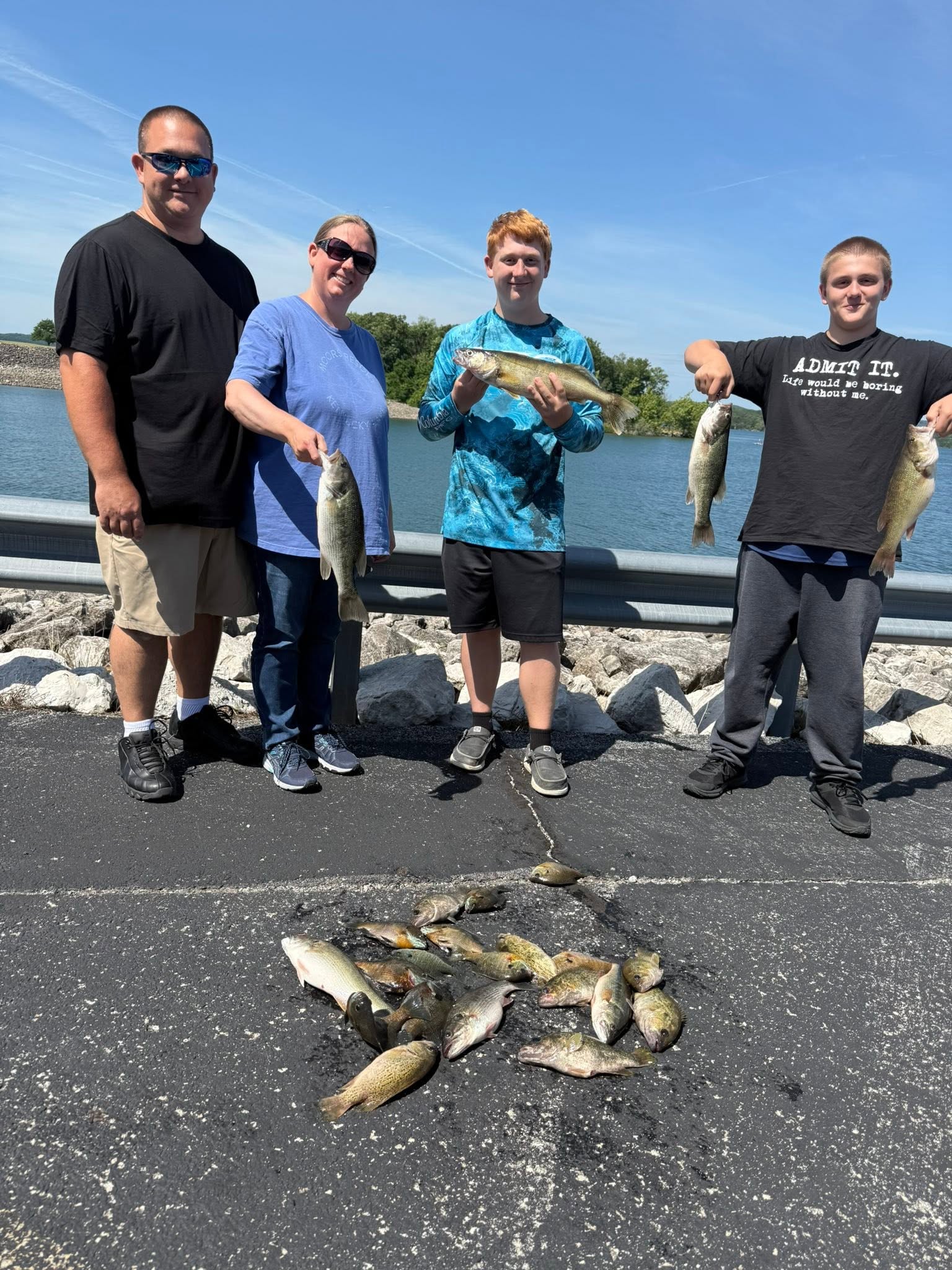 Successful fishing trip in Branson MO with walleye and spotted bass catch displayed on ground