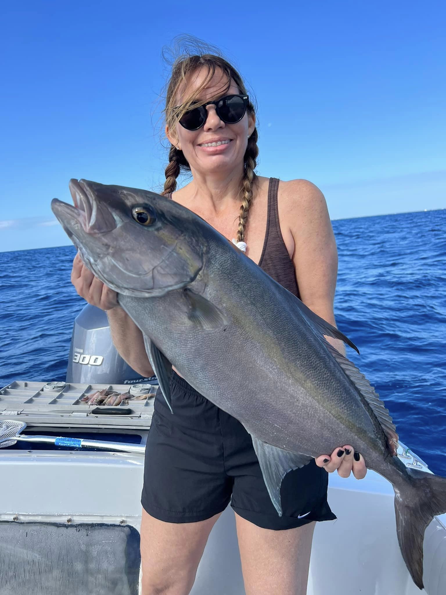 A fisherman holding a large Greater Amberjack catch in Islamorada.