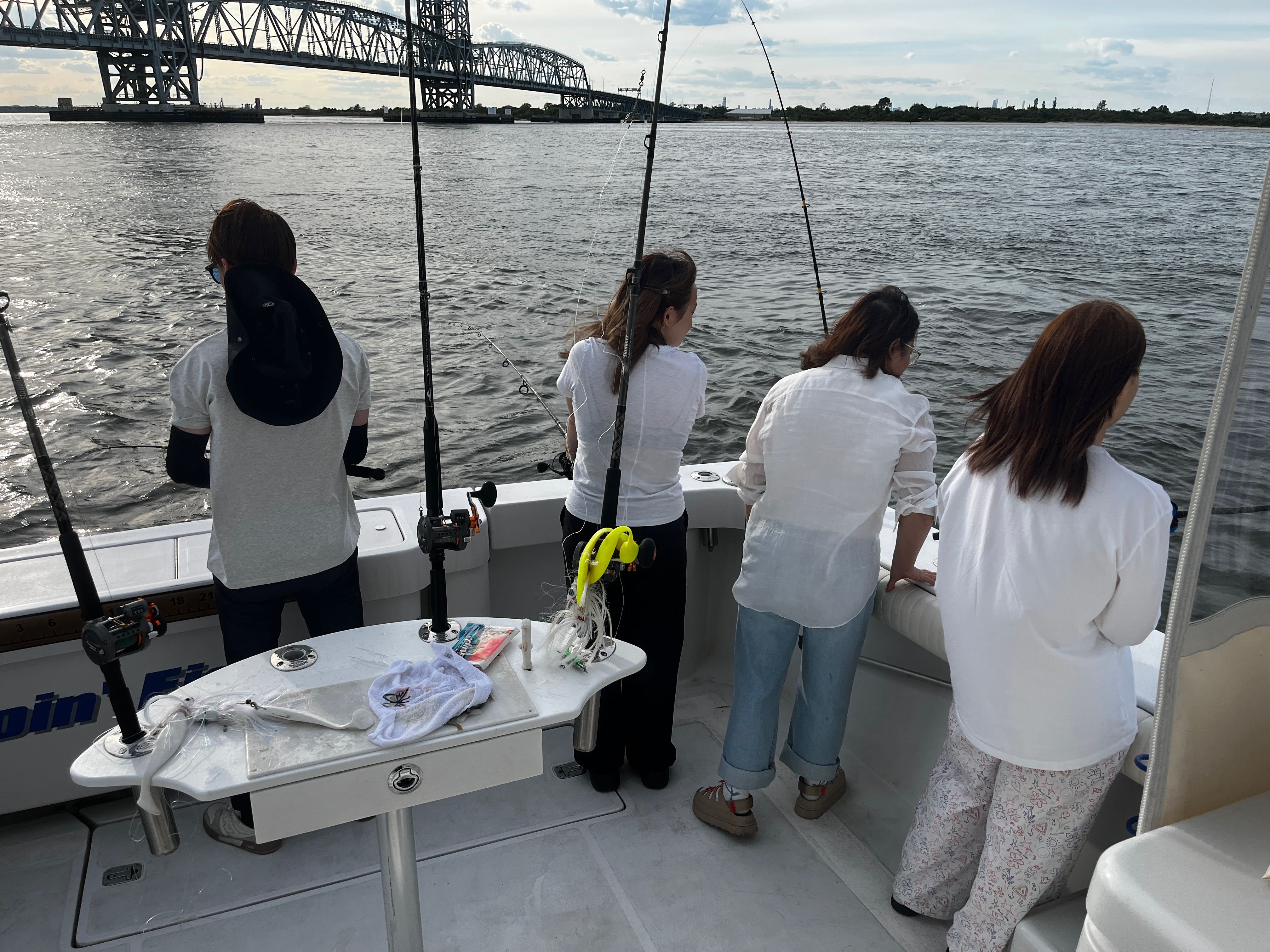 Fishing charter boat with anglers fishing near bridge in New York City waters