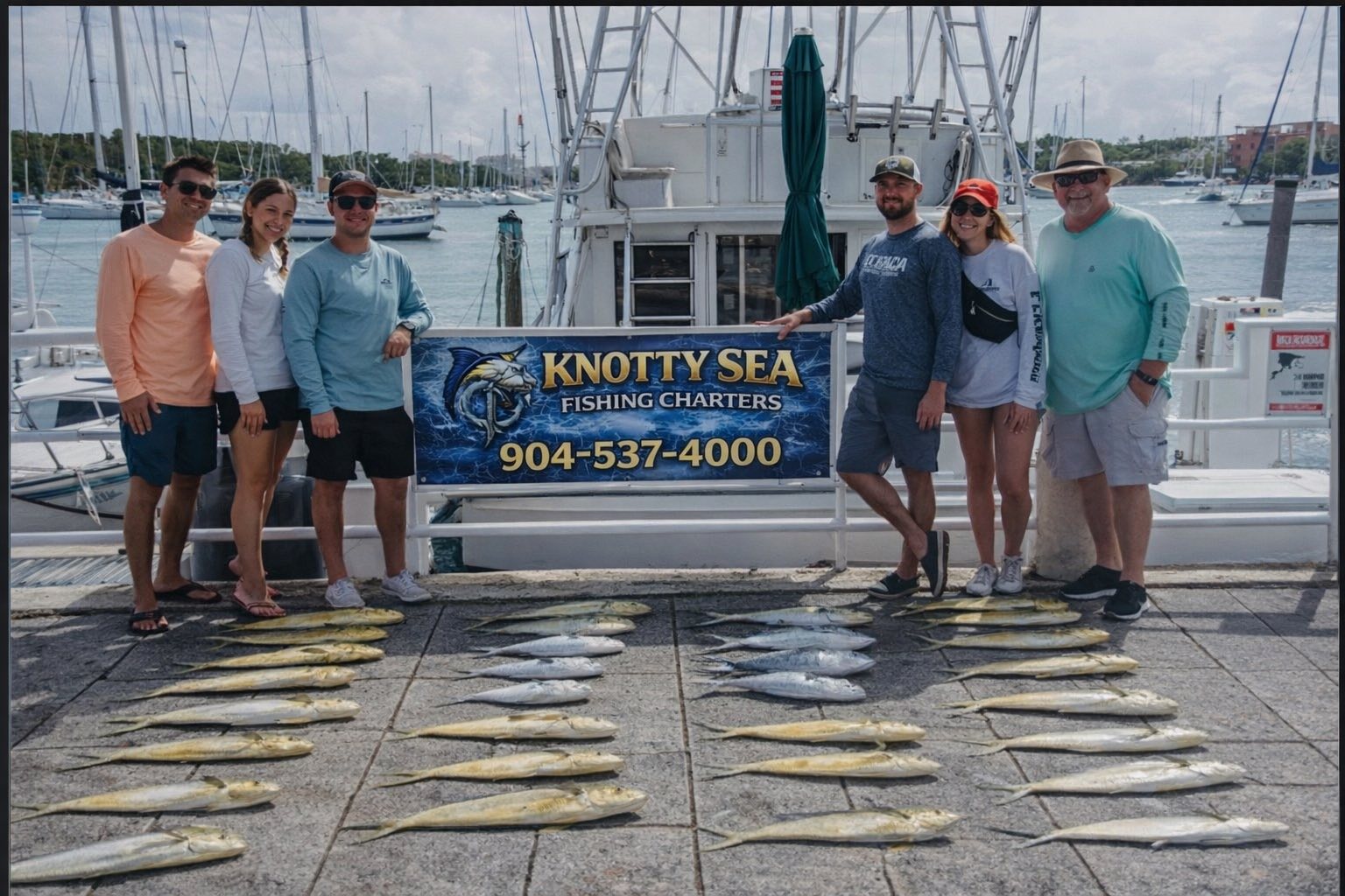 Fishing charter catch displayed on dock with charter boat in Port Orange FL marina