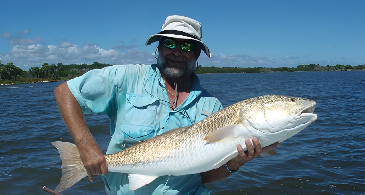 A person fishing for a large 23-inch redfish in Florida