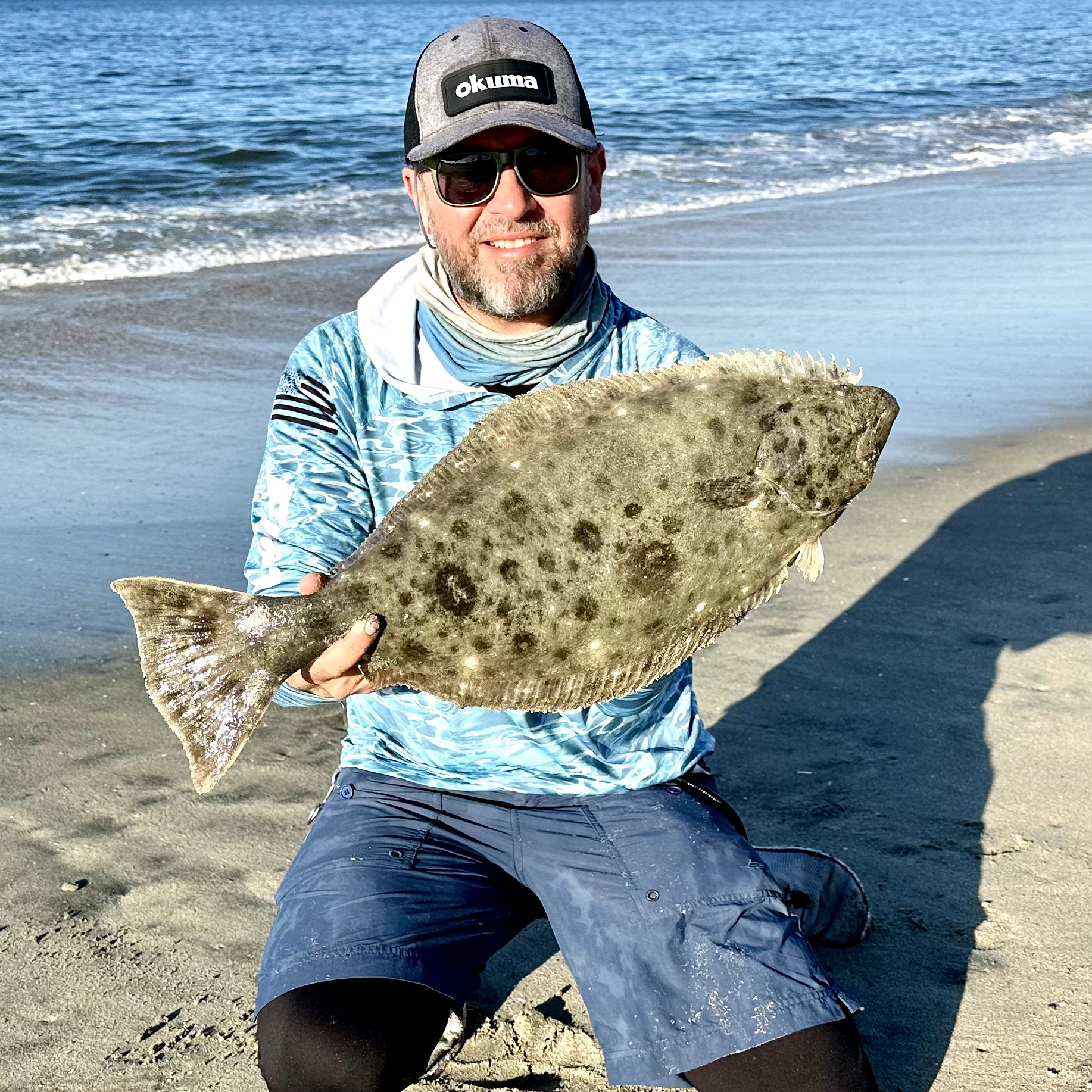 A fisherman holding a 20-inch fish in Huntington Beach