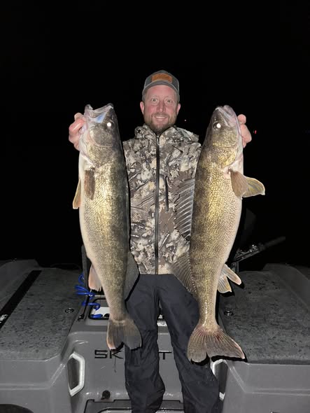 Two large walleye caught fishing in Traverse City Michigan displayed on boat deck at night