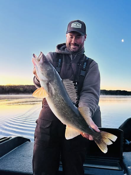 Angler holding walleye fish on boat in Traverse City MI waters