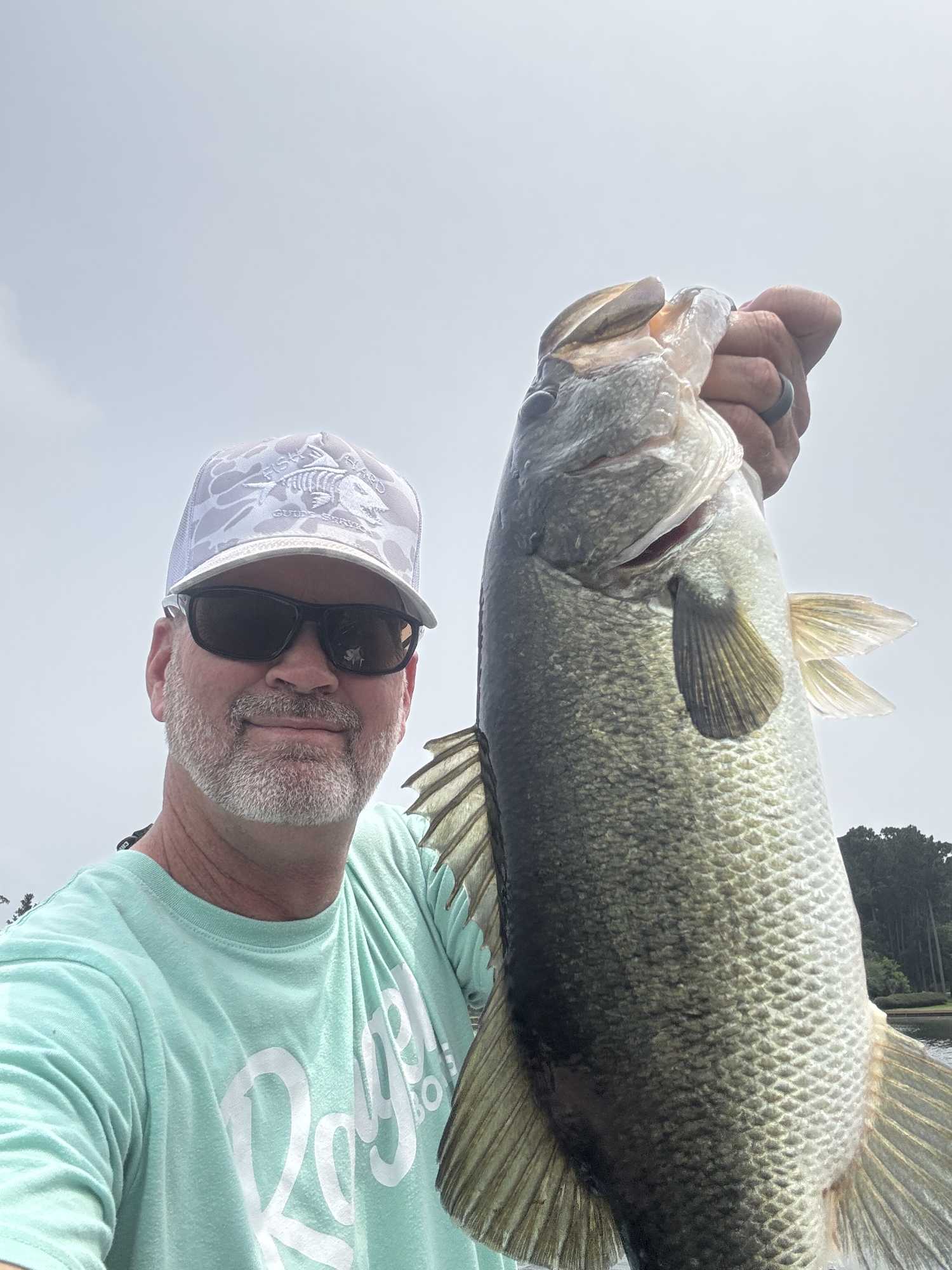 Large bass being held up after successful catch in Willis TX fishing trip