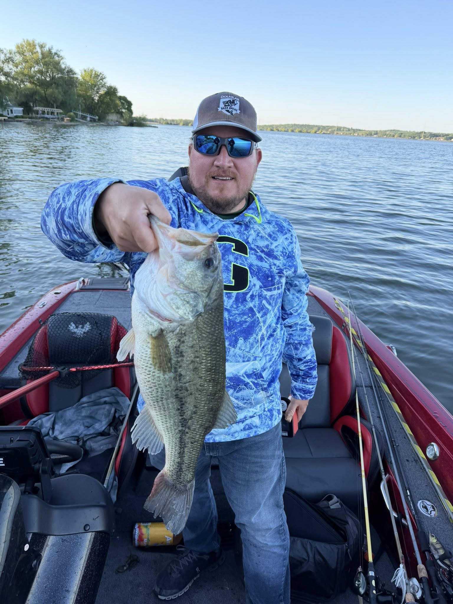 Angler holding caught bass on fishing boat in North Tonawanda NY lake