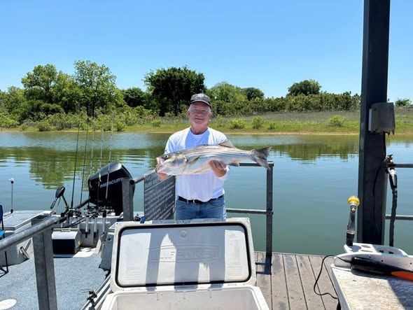 Angler holding caught fish on boat dock at Kingston OK lake