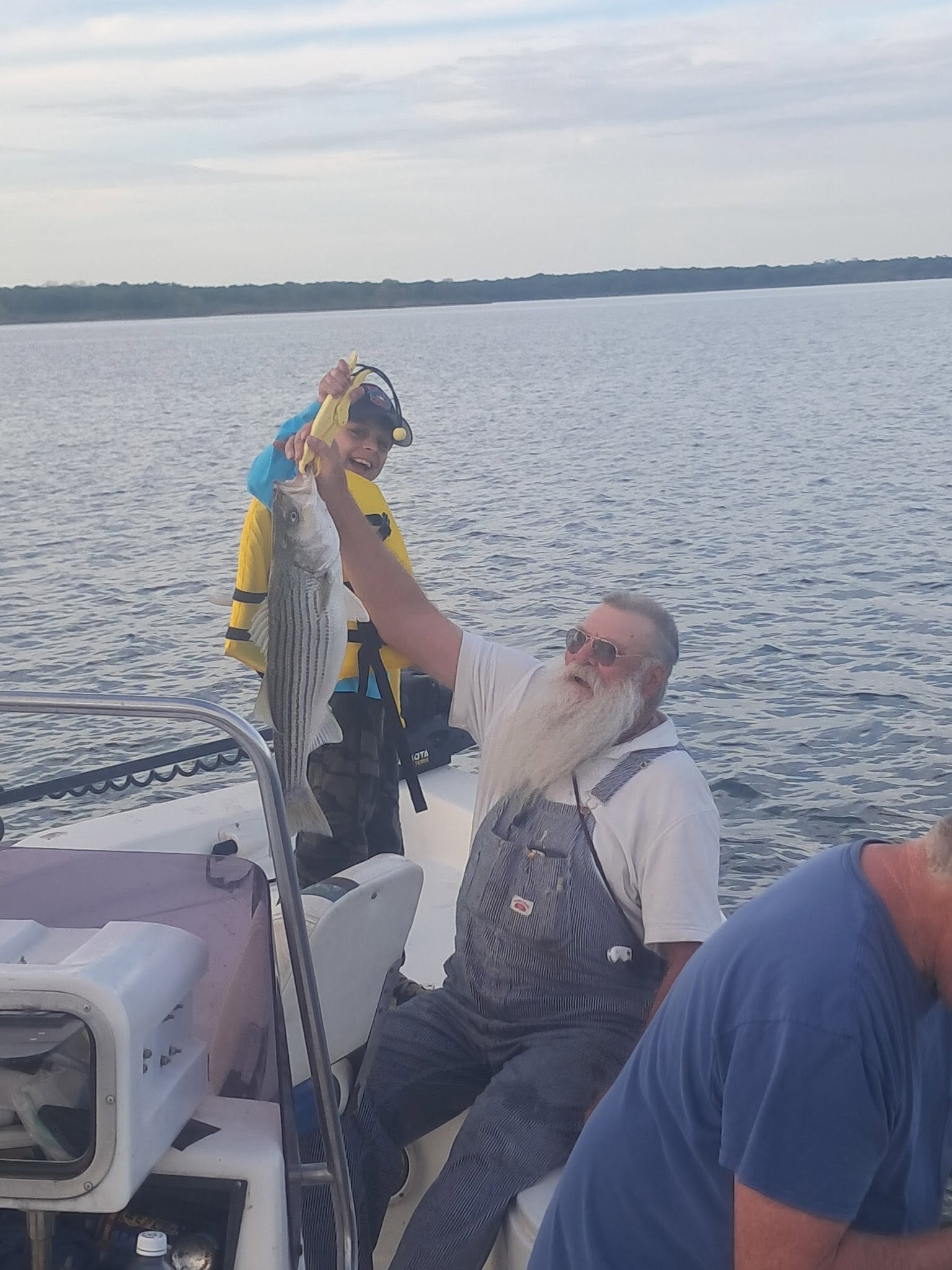 Freshly caught striped bass being held up on fishing boat at Kingston OK