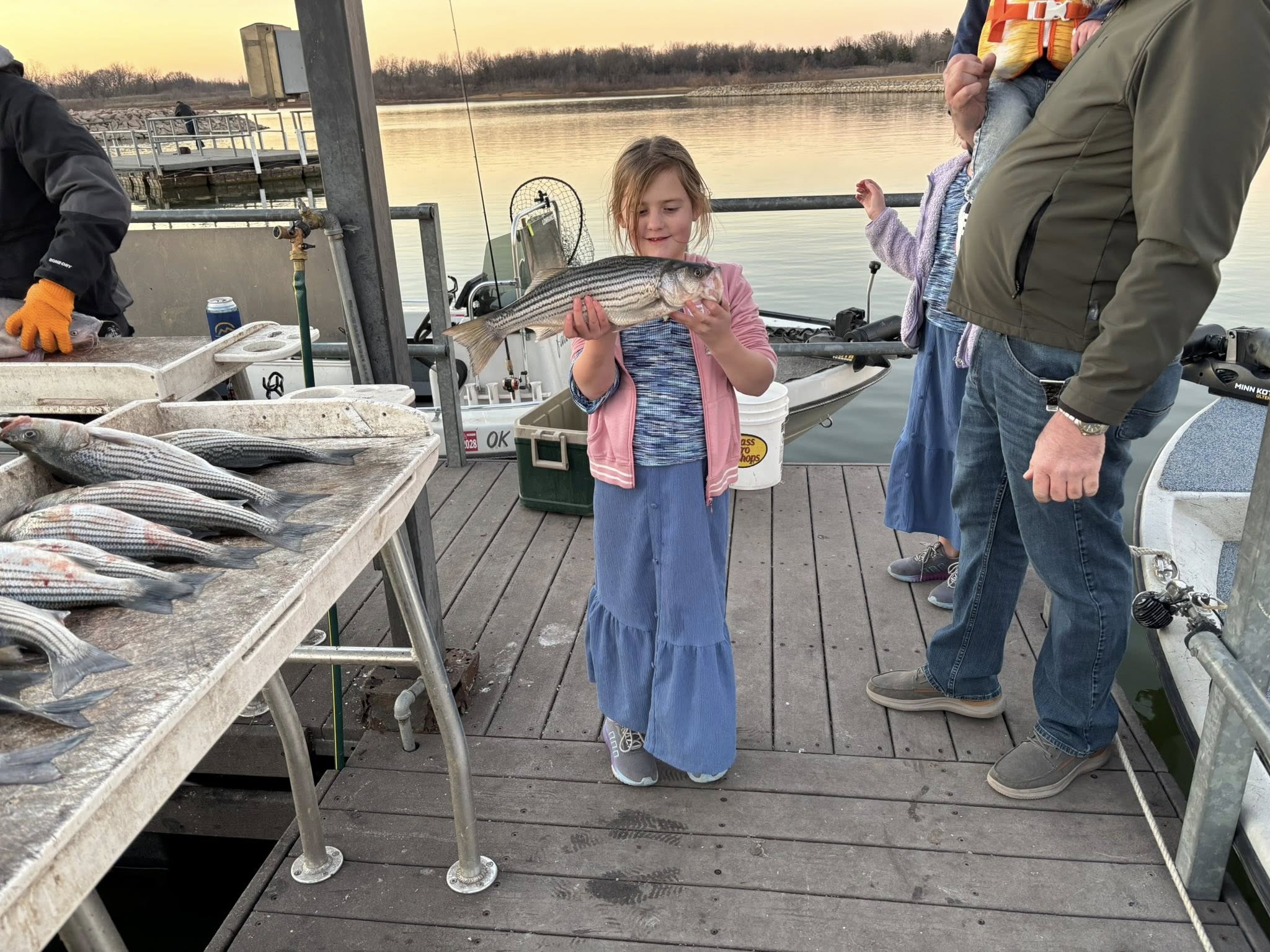 Striped bass fishing success at Kingston OK marina dock with fresh catch displayed