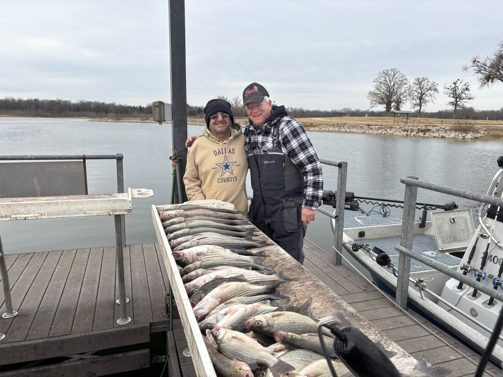 Successful white bass fishing trip at Kingston OK with large catch displayed on boat dock