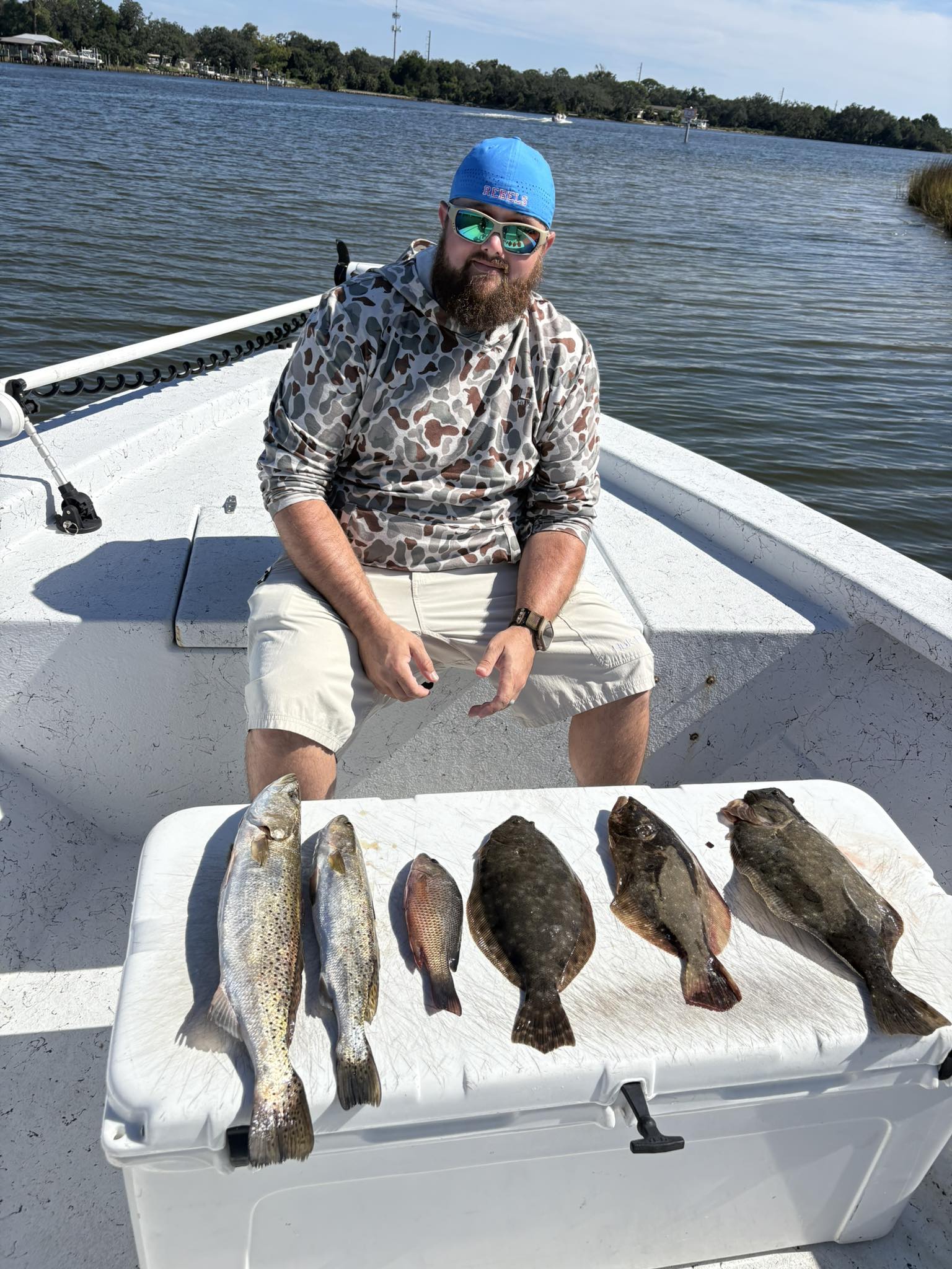 Fishing catch display showing speckled trout, flounder, and grey snapper on boat deck in Pensacola FL