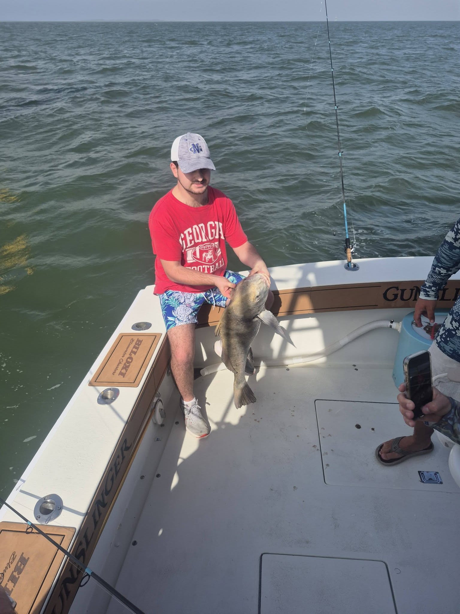 Angler holding caught fish on fishing boat in Biloxi MS waters