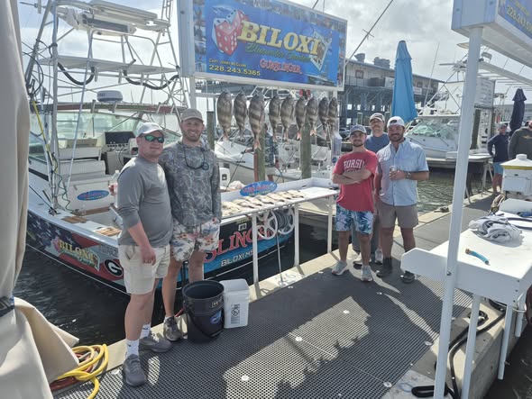Fishing charter boat displaying multiple caught fish hanging on display rack at Biloxi MS marina