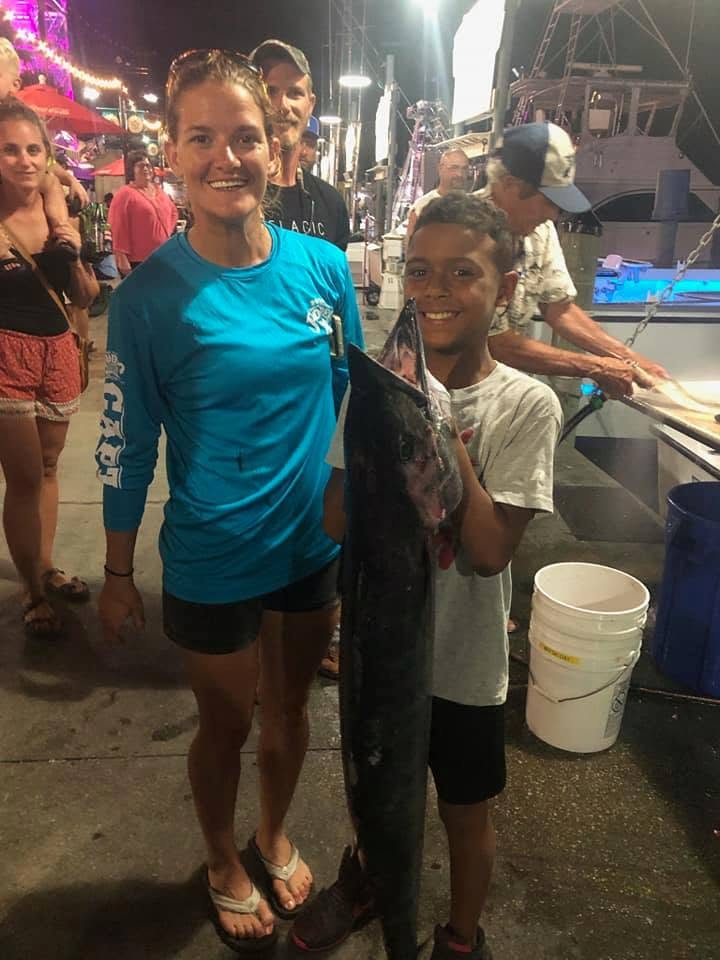 Large fish catch displayed at marina dock in Destin FL at night