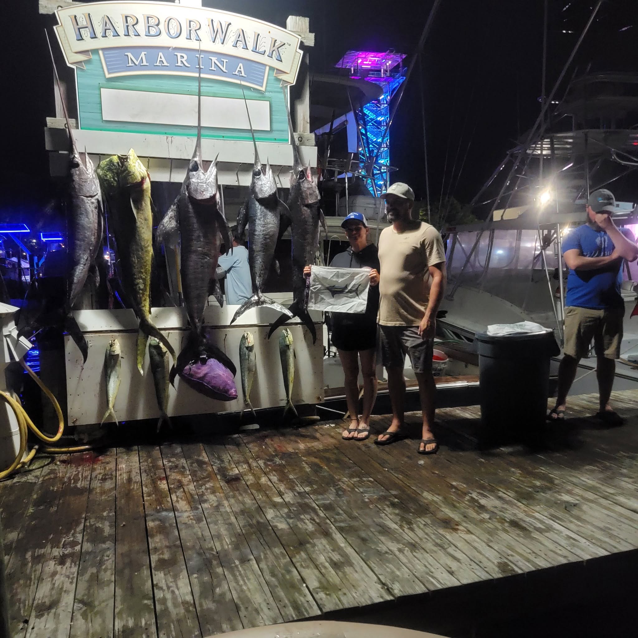 Deep sea fishing catch display at Harbor Walk Marina in Destin FL showing King Mackerel, Mahi Mahi, and Swordfish hanging on dock