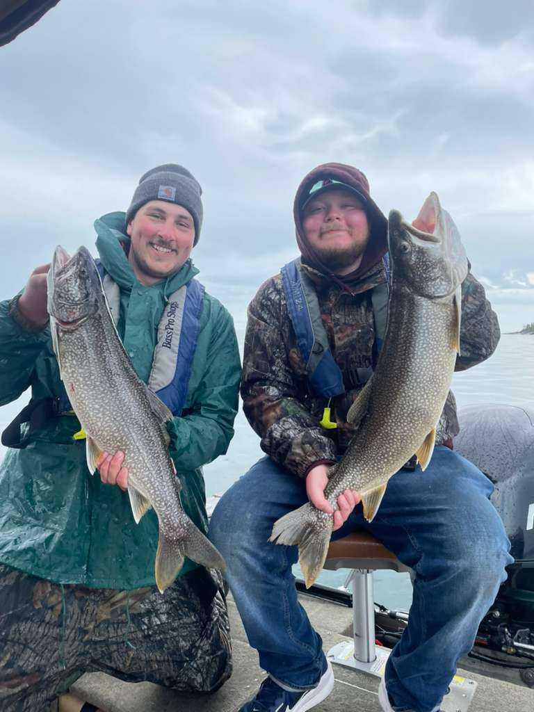 Two anglers displaying large lake trout caught during fishing trip in Nipigon ON