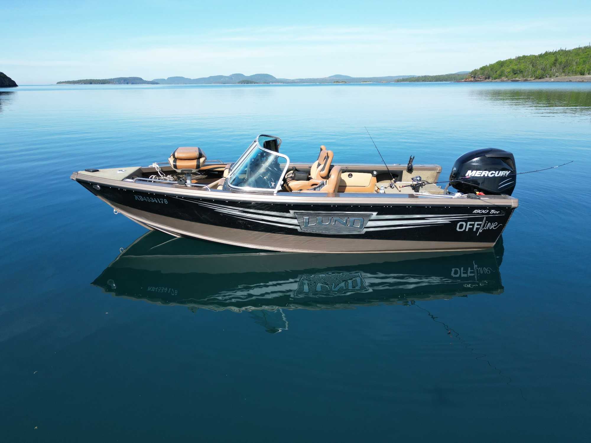 Lund fishing boat with Mercury outboard motor on calm lake waters in Nipigon Ontario