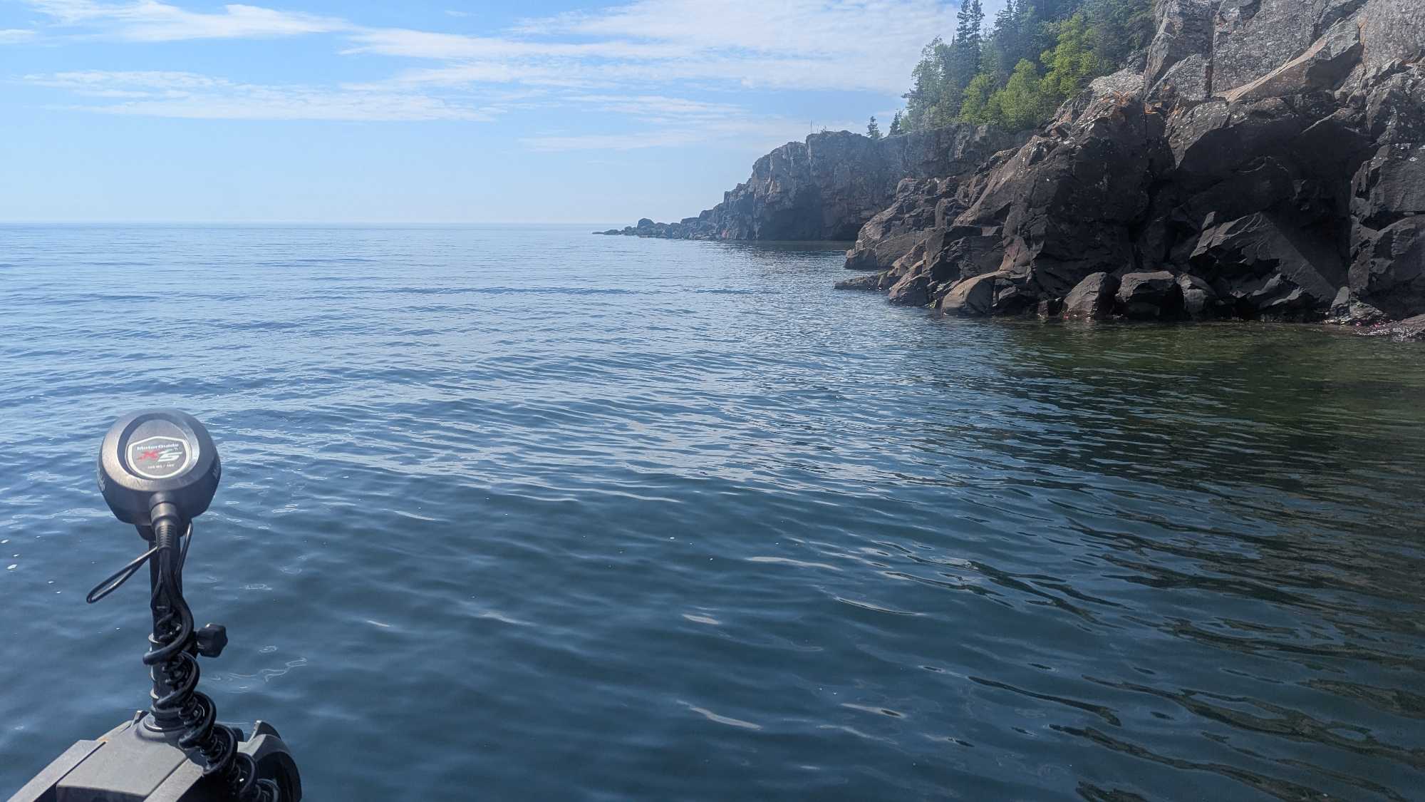 Fishing boat motor on calm waters near rocky shoreline in Nipigon Ontario