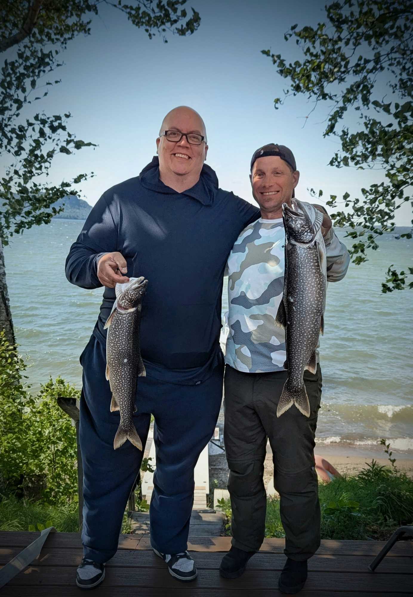 Two anglers displaying caught lake trout on fishing tour in Nipigon ON