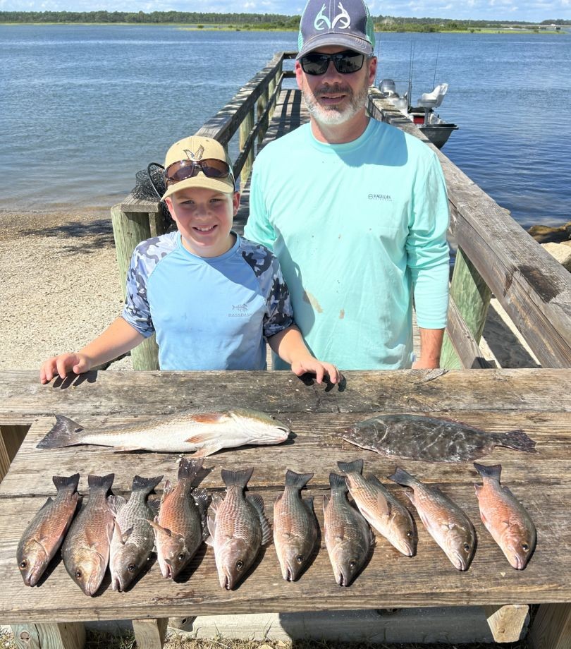 Successful fishing trip in St. Augustine FL showing redfish and grey snapper catch on wooden dock