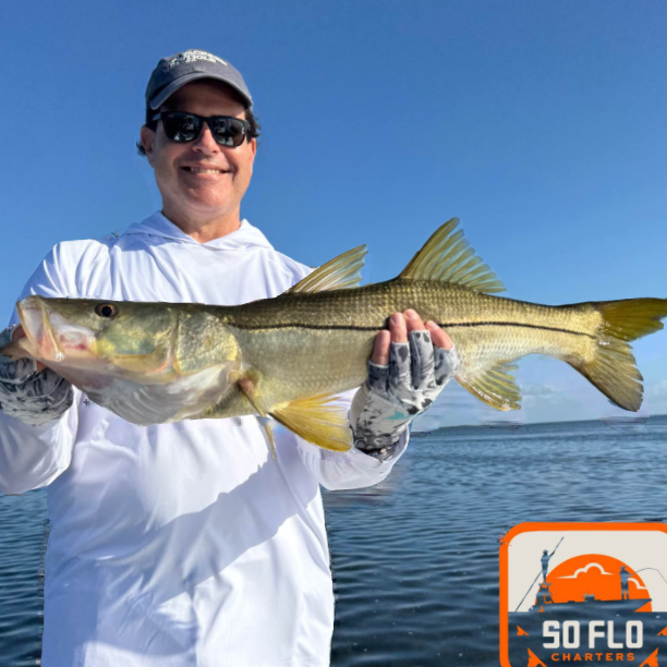 Angler holding large snook catch while fishing in Islamorada FL waters