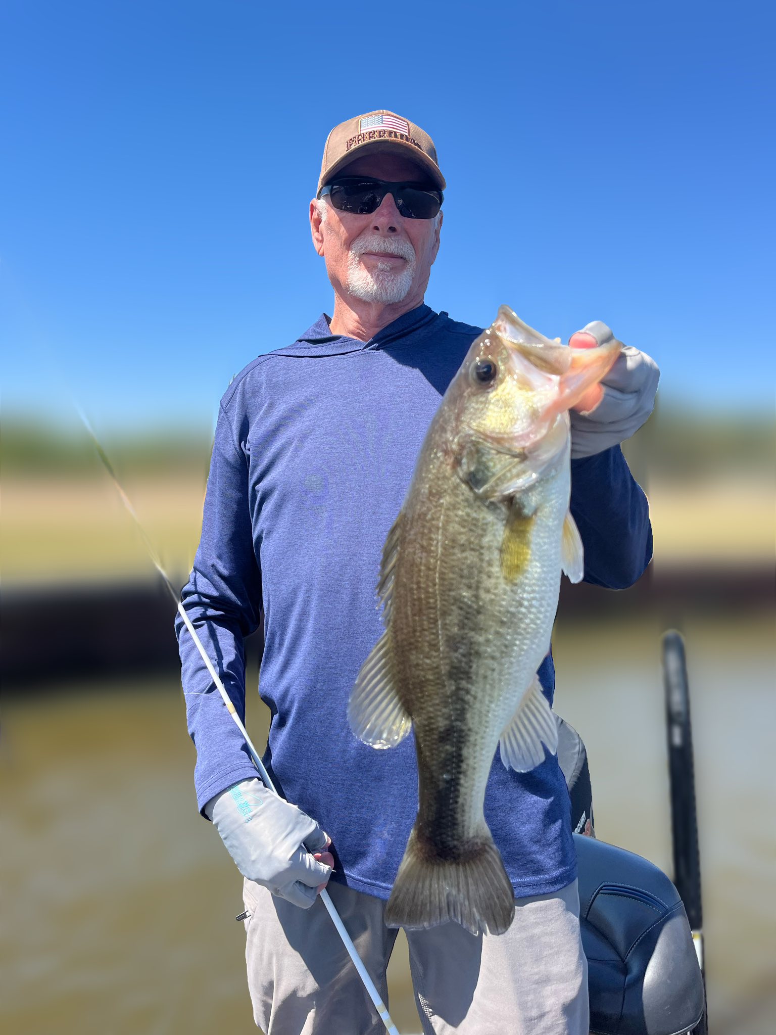 Angler holding large bass fish on boat in Ridgeland MS