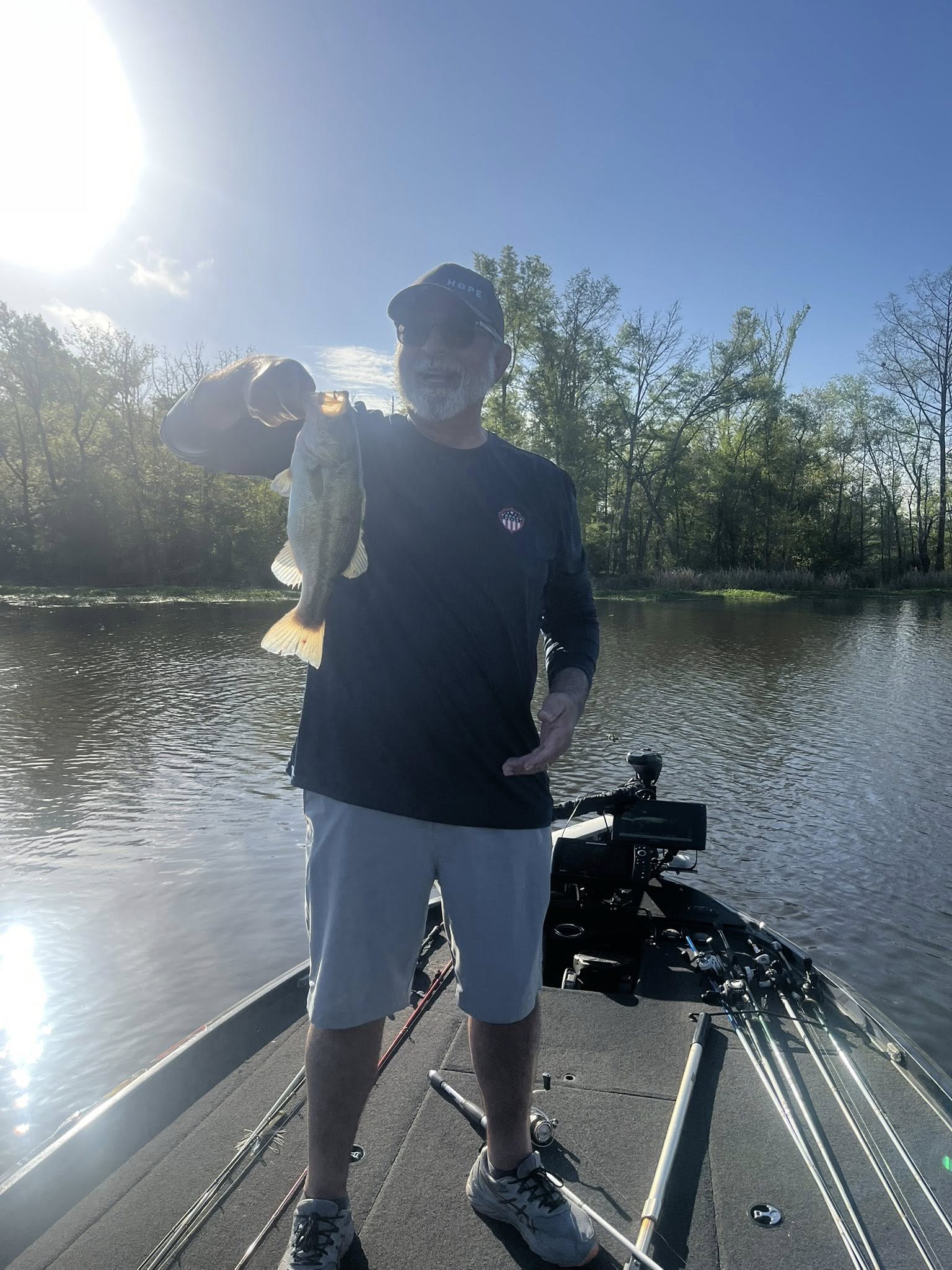 Angler holding freshly caught bass on fishing boat in Ridgeland MS