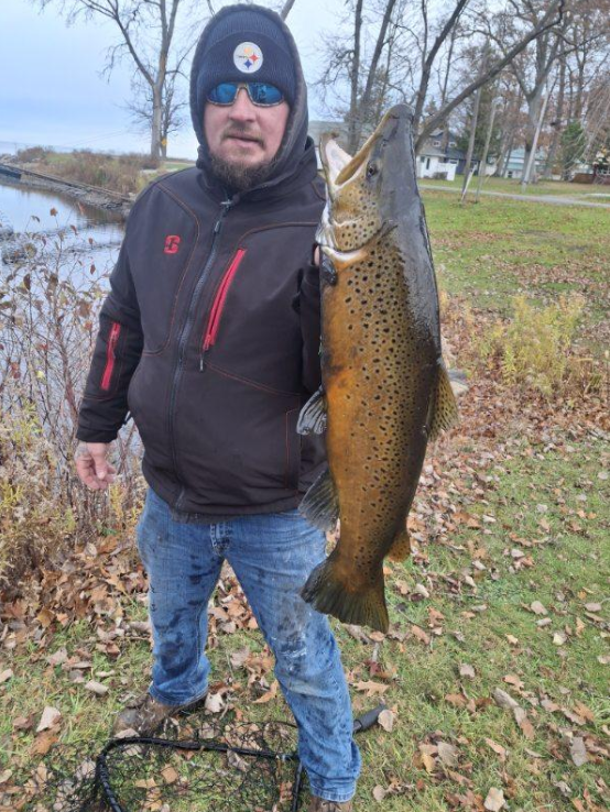 Angler catching a rainbow trout in Oswego