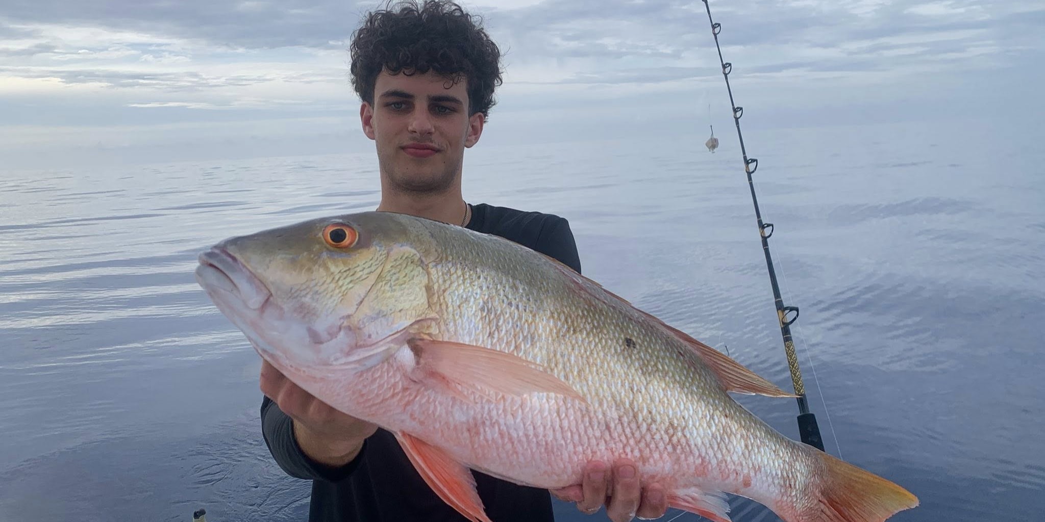 Family fishing boat with kids catching snapper in calm Islamorada waters, guided charter trip