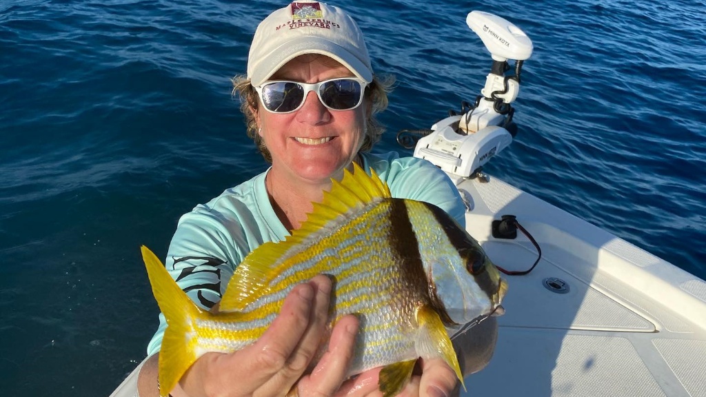 A person fishing in Florida with a 15-inch fish