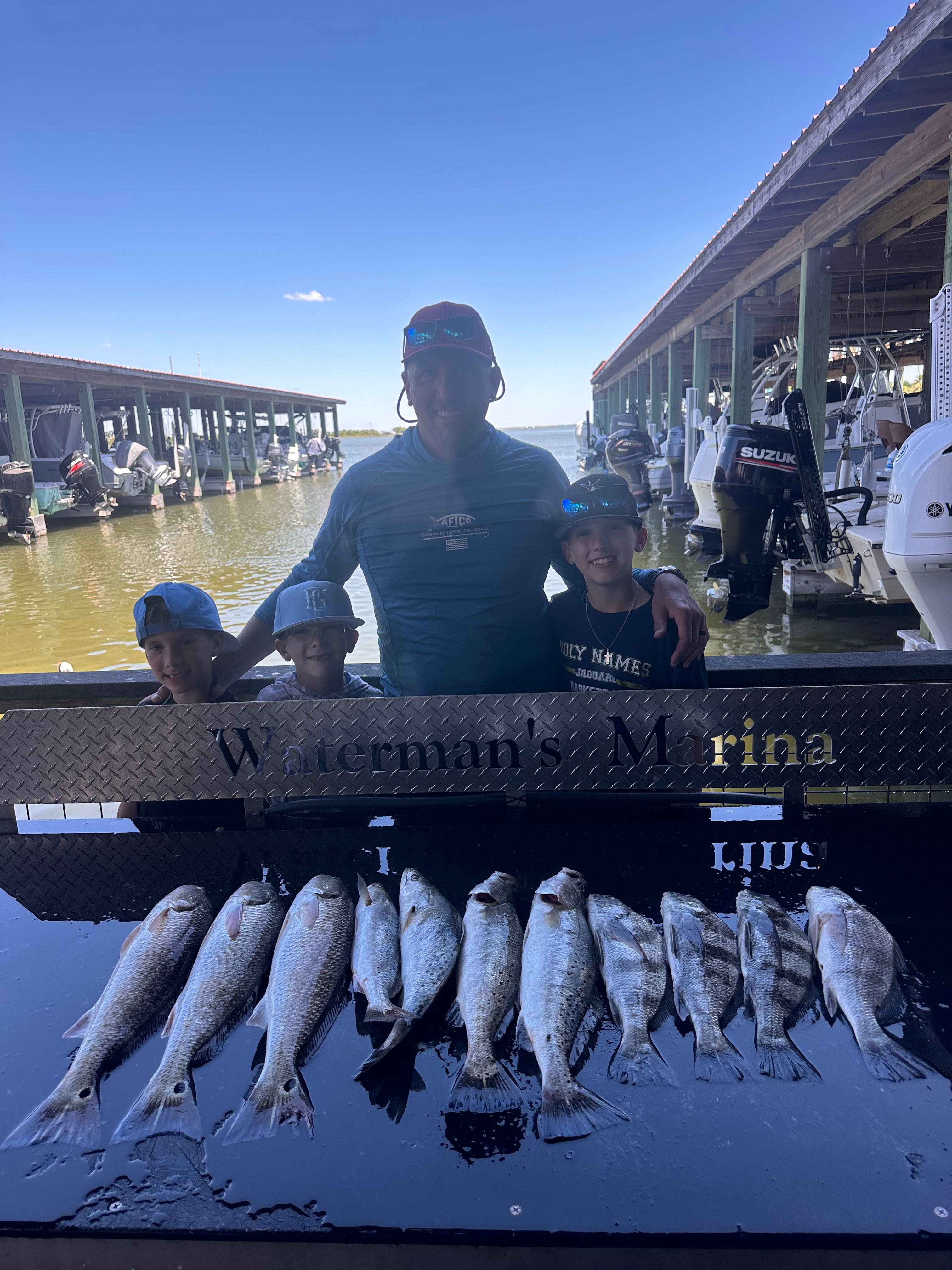 Successful fishing trip in Galveston TX showing caught redfish, black drum, and speckled trout displayed on boat