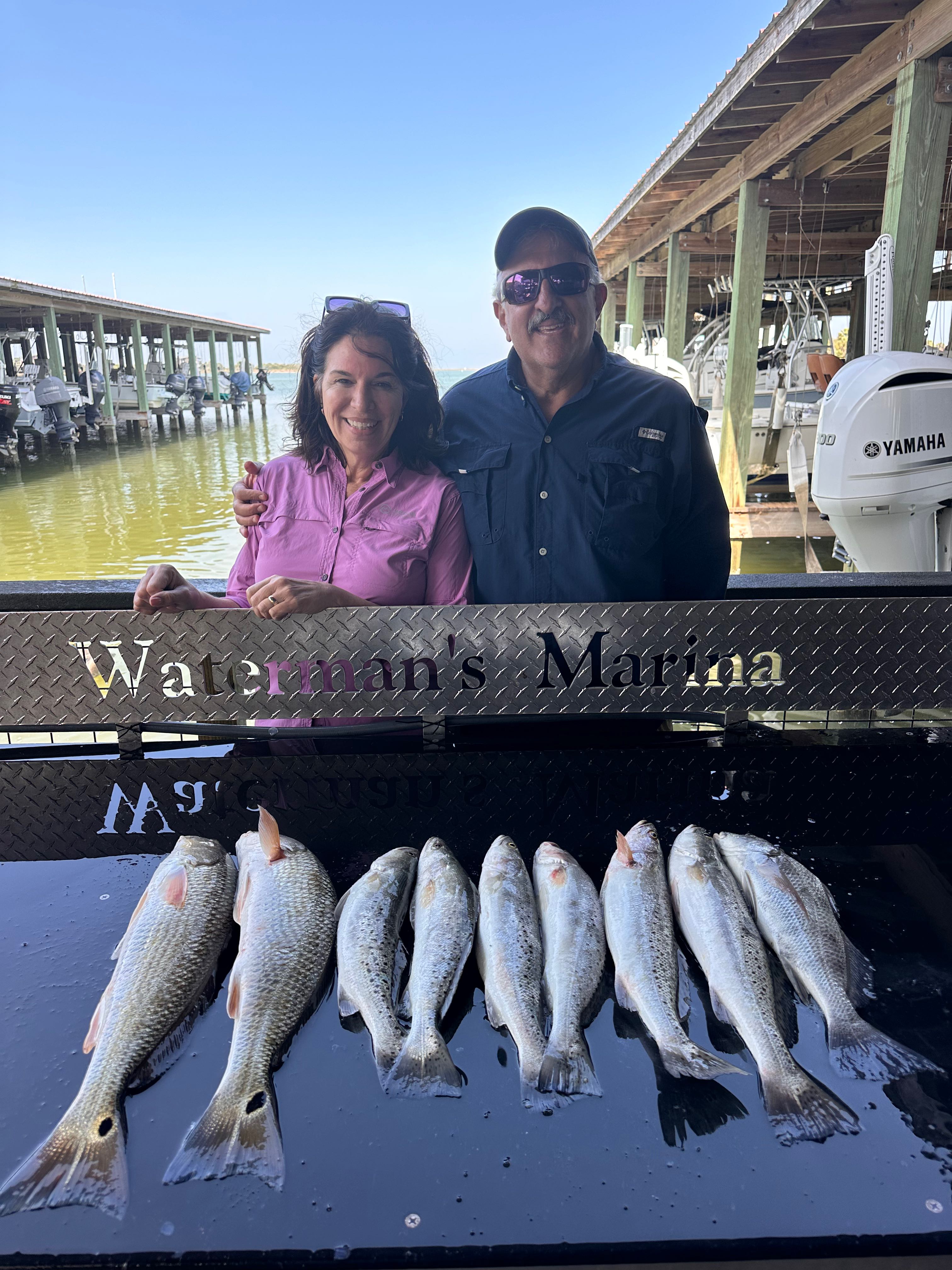 Fresh catch of redfish, black drum, and speckled trout displayed on boat deck at Galveston TX marina