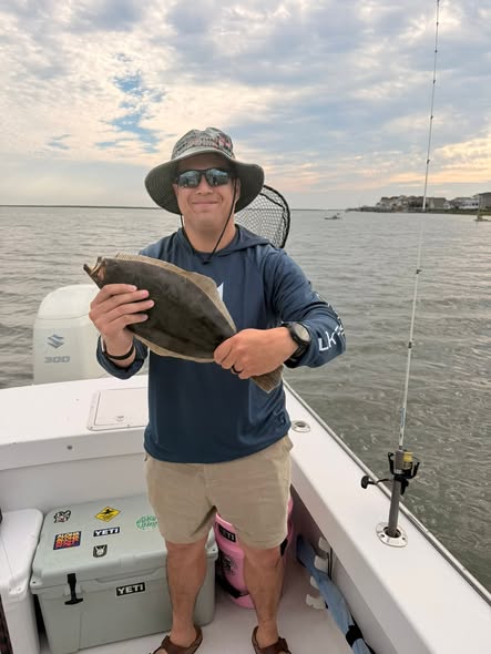 Angler holding caught fish on boat in Brigantine NJ waters