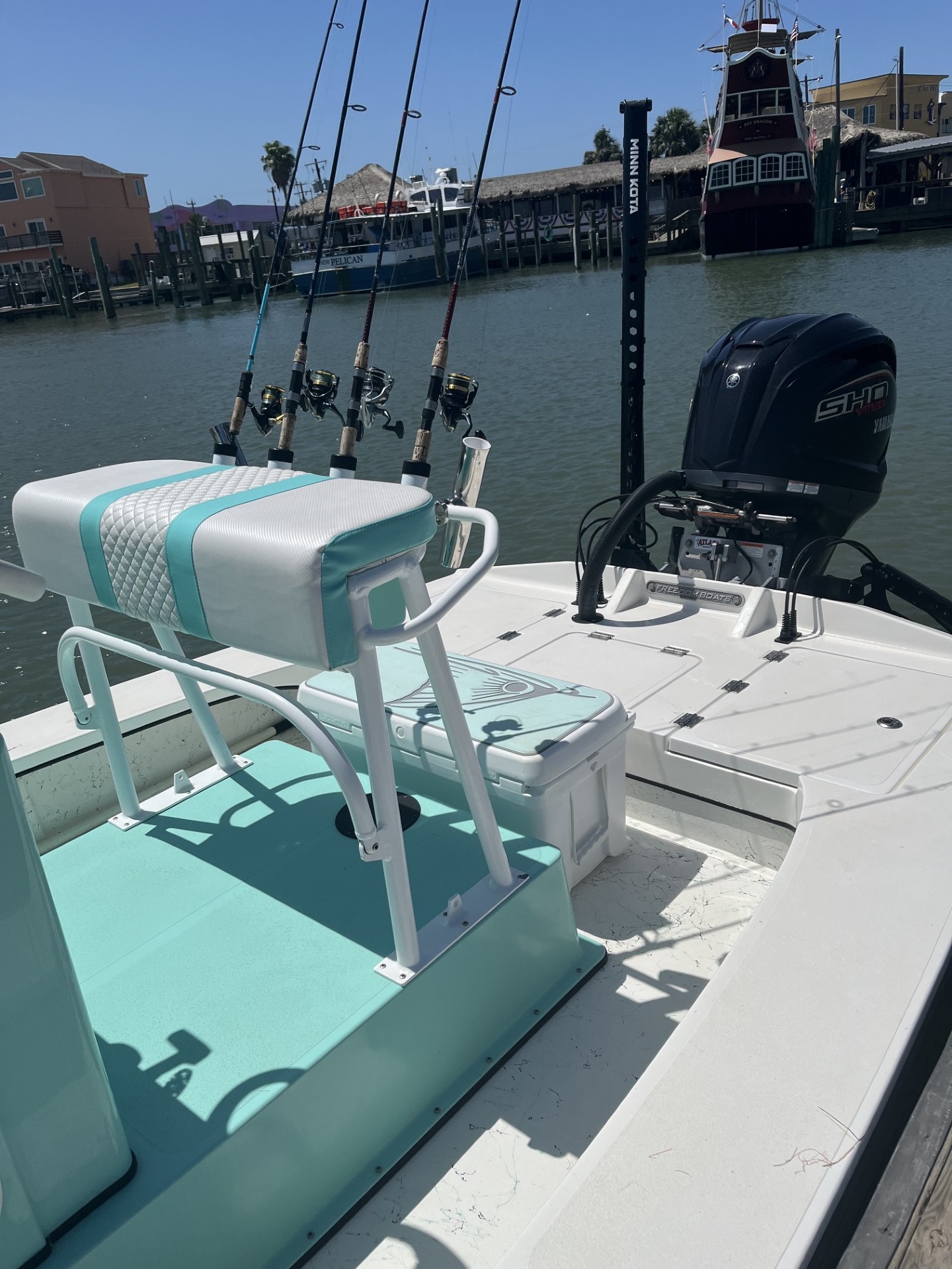 Fishing boat with multiple rod holders and outboard motor docked at Port Aransas TX marina