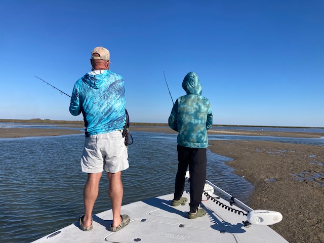 Two anglers fishing from boat deck in shallow flats waters Port Aransas TX