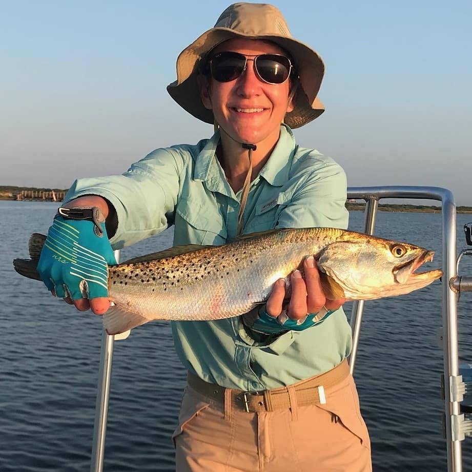 A fisherman holding a spotted weakfish, 18 inches long, in Corpus Christi