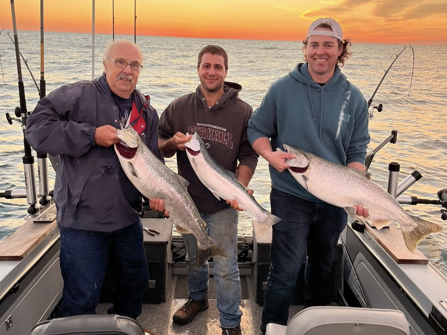 Three anglers displaying freshly caught Chinook salmon on fishing boat in Sheboygan WI