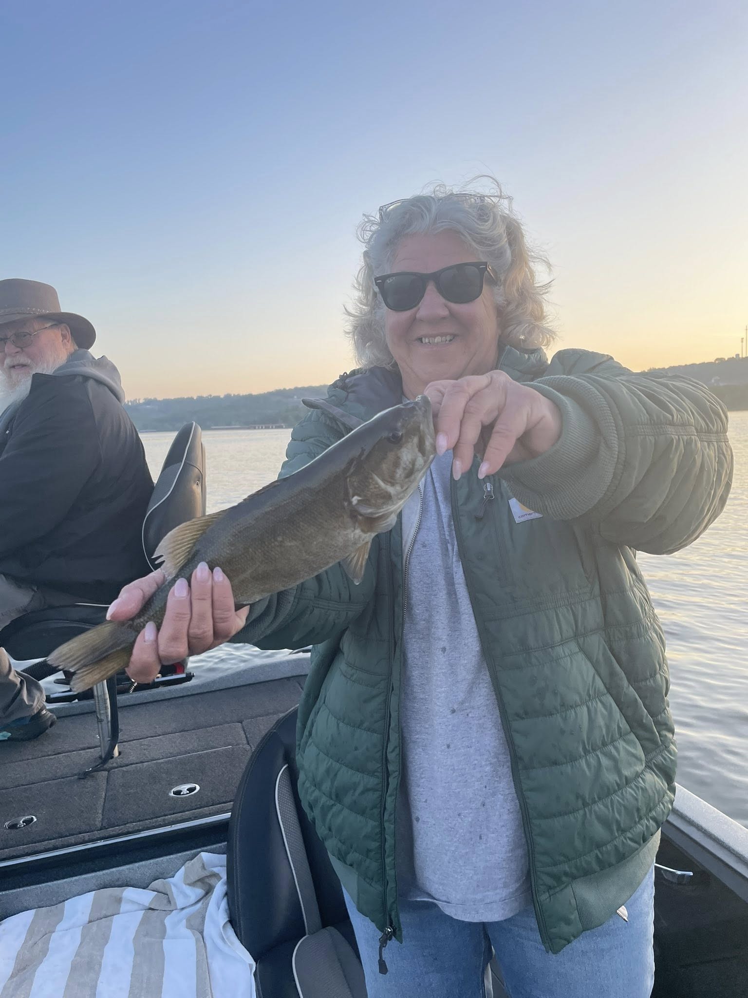 Angler holding freshly caught bass on fishing boat in Branson MO