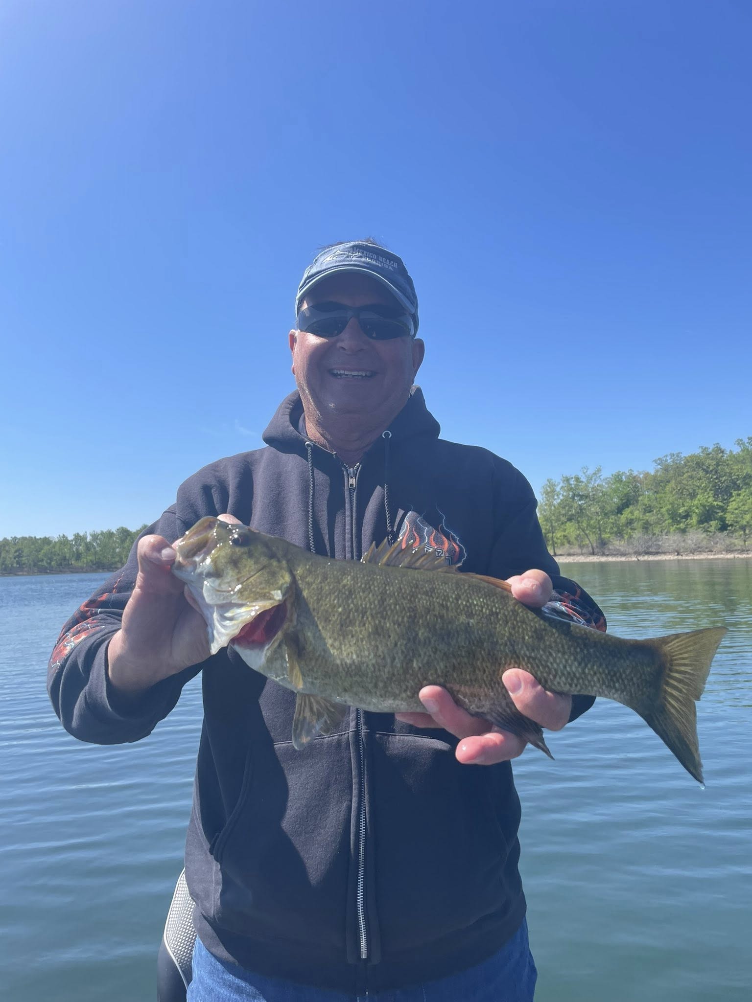 Angler holding large bass fish on lake in Branson MO