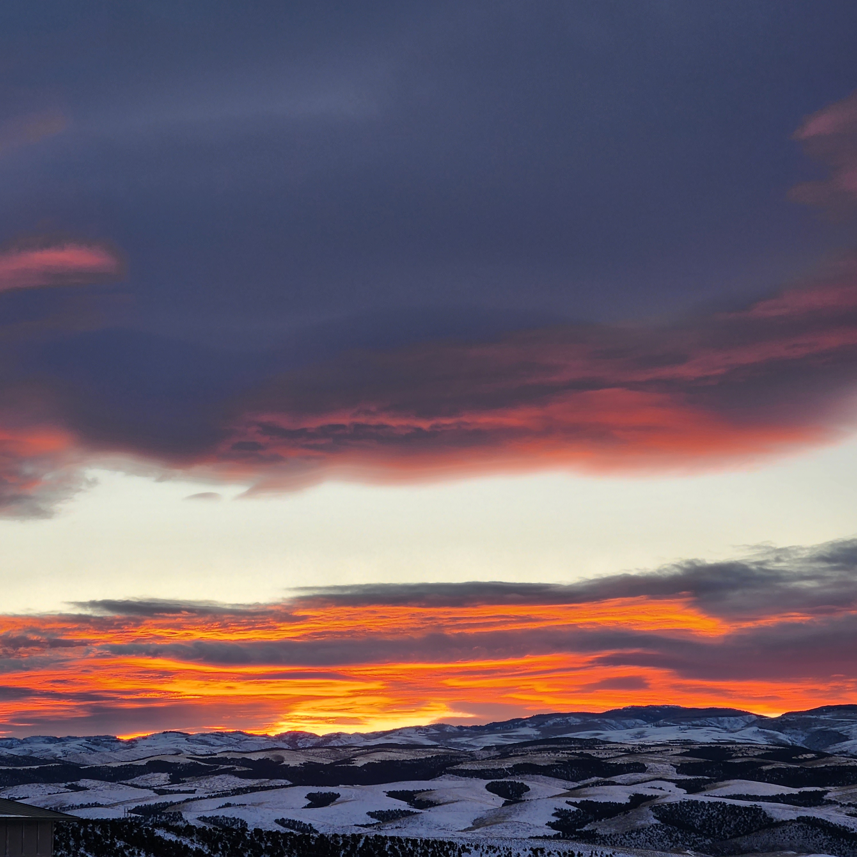 Dramatic sunset over snow-covered mountains and rolling hills near Panguitch Utah