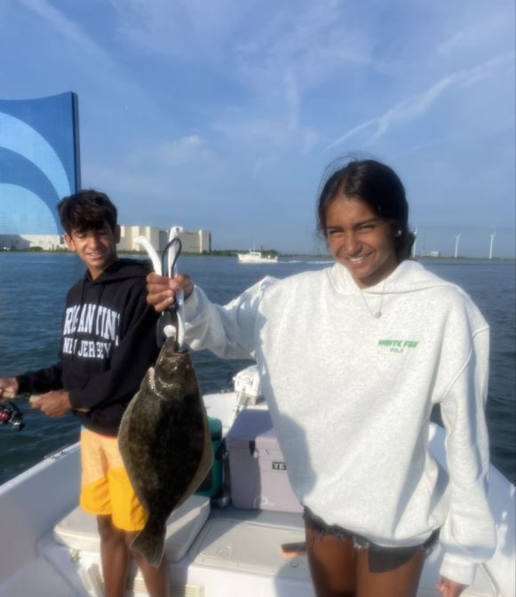 A thrilling fishing tour in NJ, with two anglers reeling in the catch of the day.