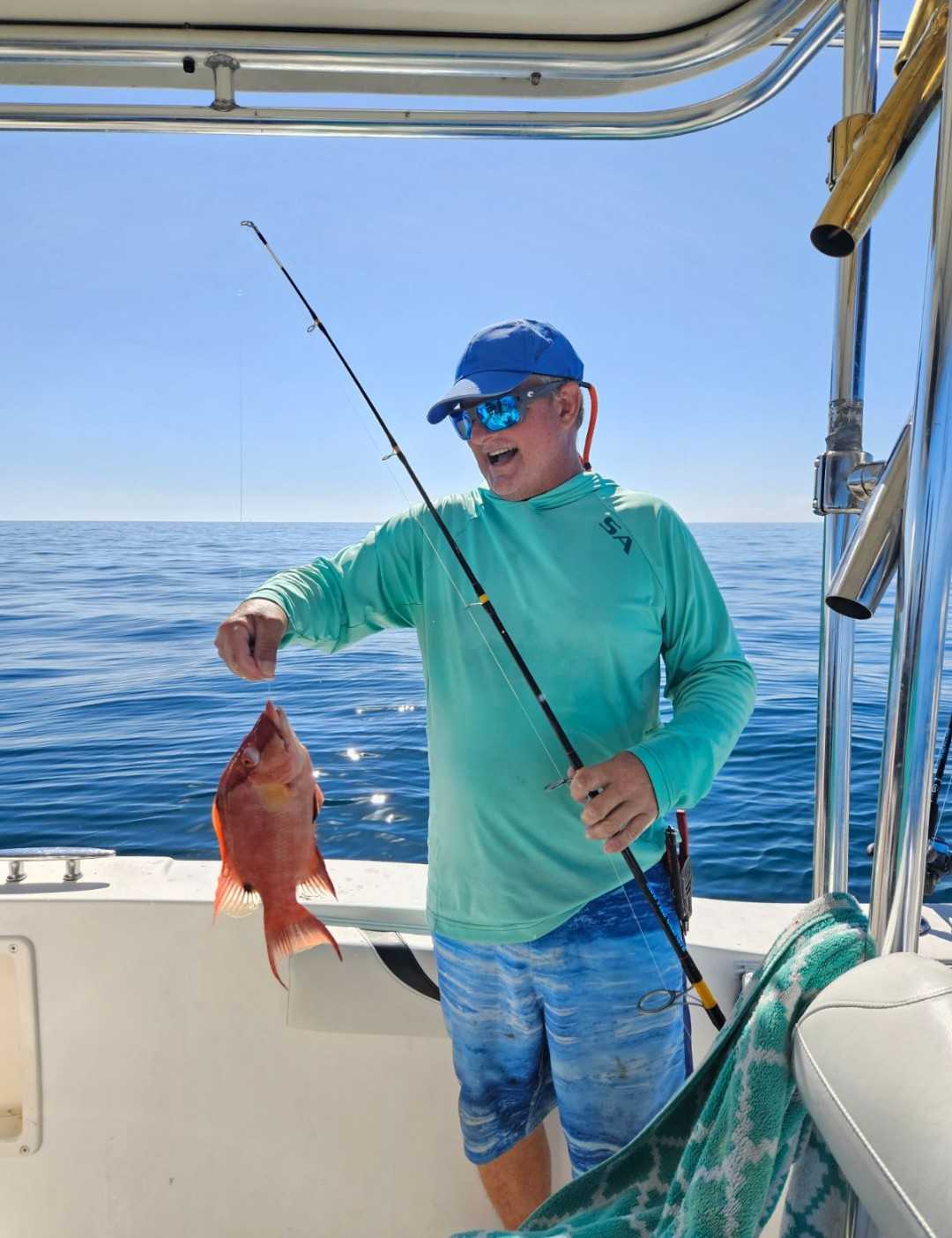 A person fishing in Clearwater with a 13-inch fish