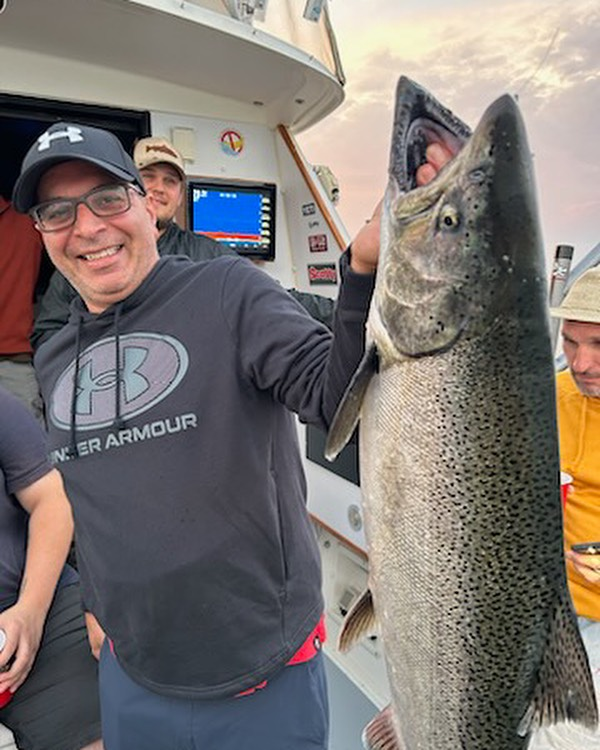 Angler holding a large rainbow trout fish in Ontario, Canada