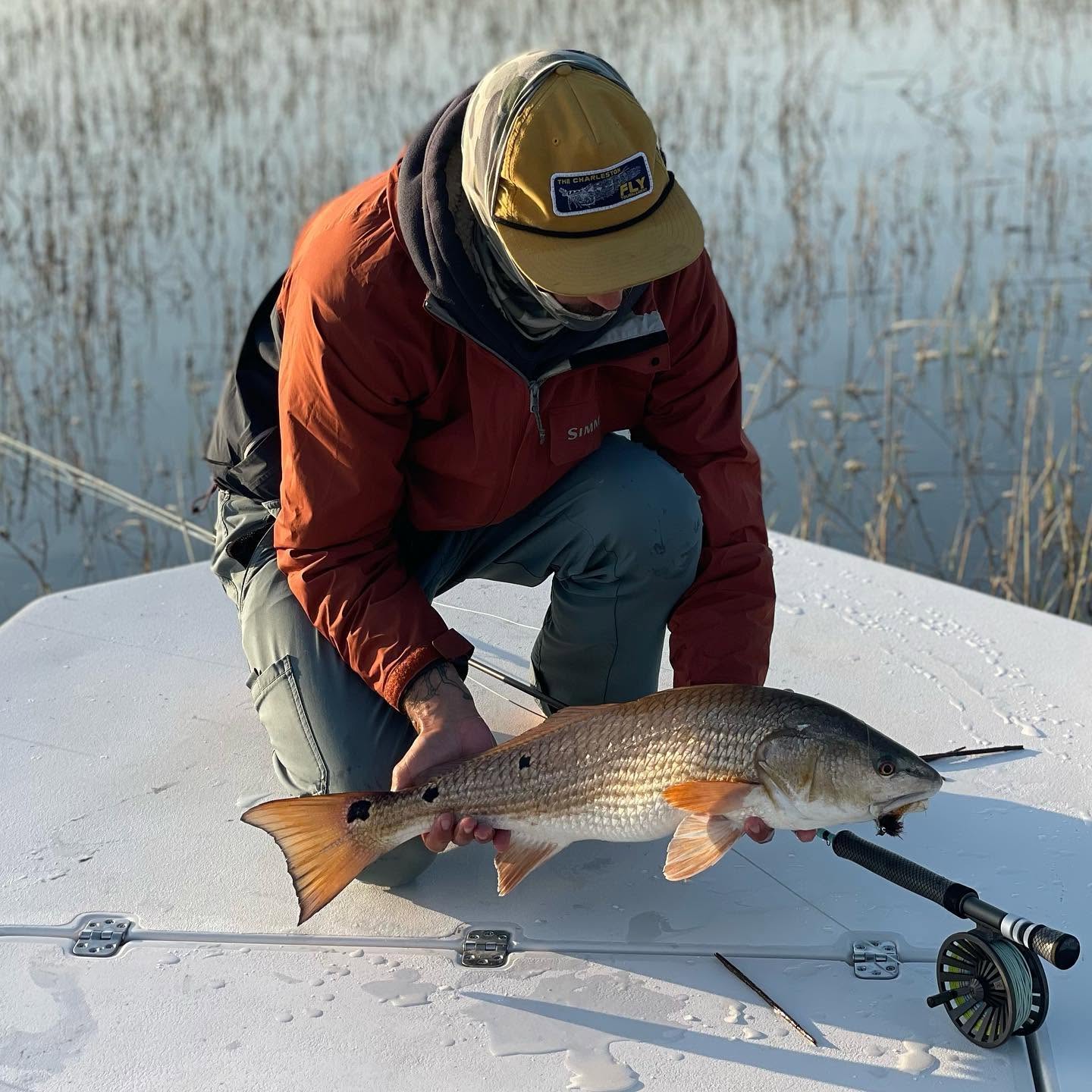 Redfish caught while fishing on Johns Island SC displayed on boat deck with fishing rod